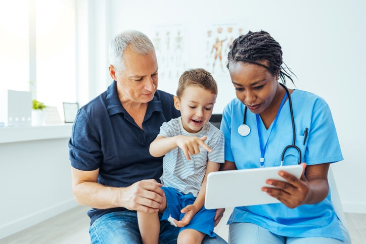 Doctor-showing-digital-solution-to-kid-and-parent